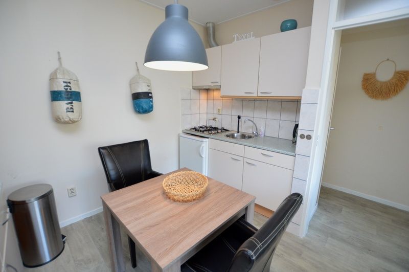 Kompakte Kueche im Apartment Kerckeland 78, Ferienhaus in De Koog, Texel, mit modernen Geraeten und Essecke.