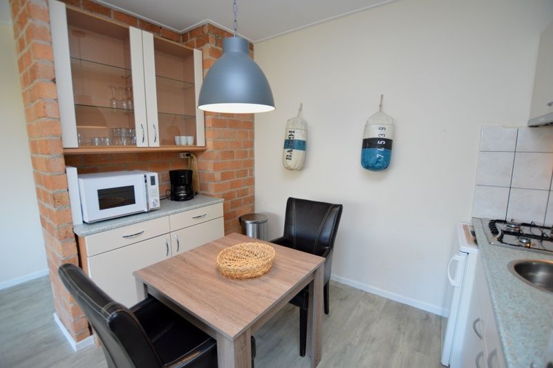 Kueche und Essbereich des Apartments Kerckeland 78, De Koog, Texel, mit praktischer Aufteilung und stimmungsvoller Beleuchtung.