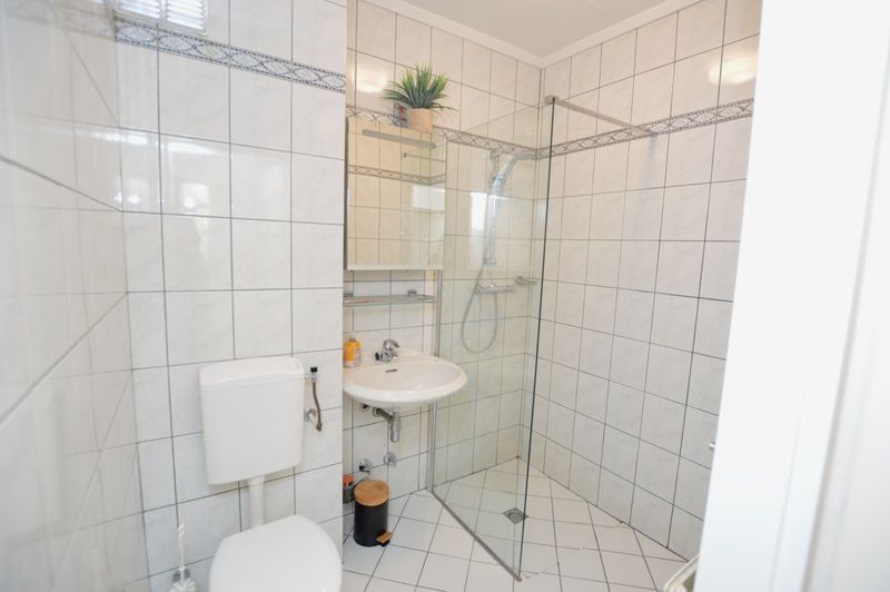 Modernes Badezimmer im Apartment Kerckeland 78, De Koog, Texel, mit geraeumiger Dusche und stilvollen Fliesen.