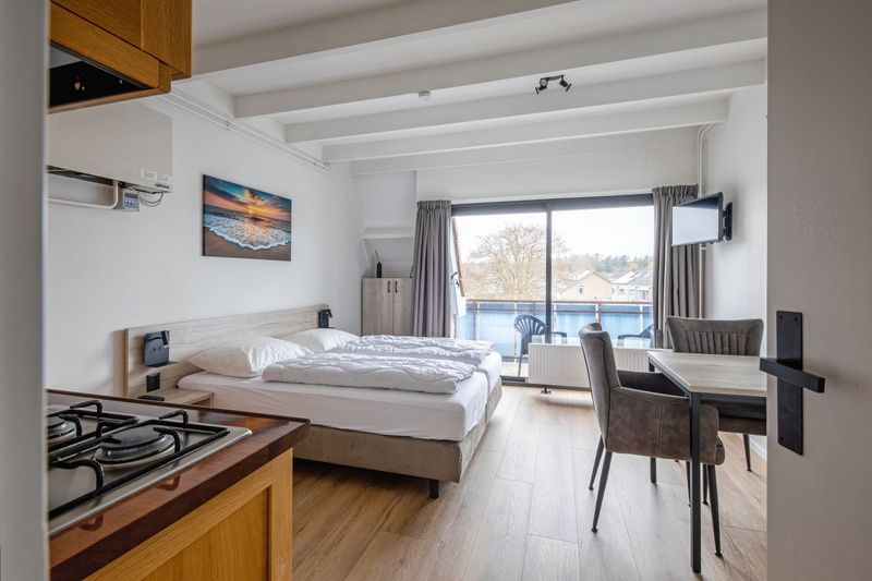 Gezellige binnenruimte van Twee persoons studio Texel met eethoek en grote ramen.