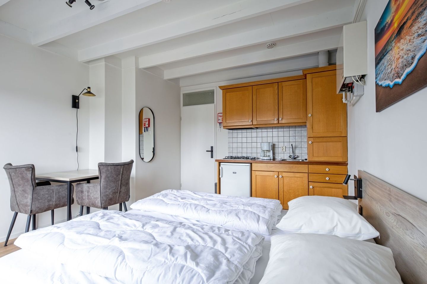 Praktische keuken in Twee persoons studio Texel met houten kasten en compacte eethoek.