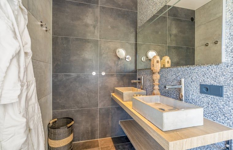 Moderne badkamer in Vakantiehuisje in De Koog met dubbele wastafel en stijlvolle afwerking op Texel.