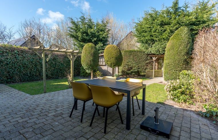 Gezellig terras bij vakantiehuisje in De Koog, Texel, omgeven door natuur.