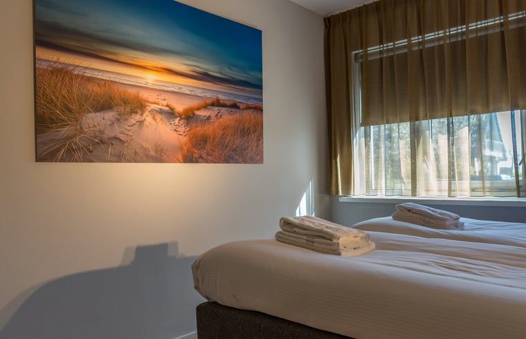 Slaapkamer met kunst en uitzicht in vakantiehuisje in De Koog, Texel.