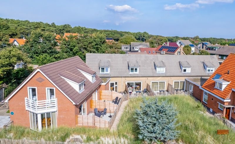 Luchtfoto van Vogelweelde vakantiehuis in De Koog, Texel, omgeven door duinen en natuur.
