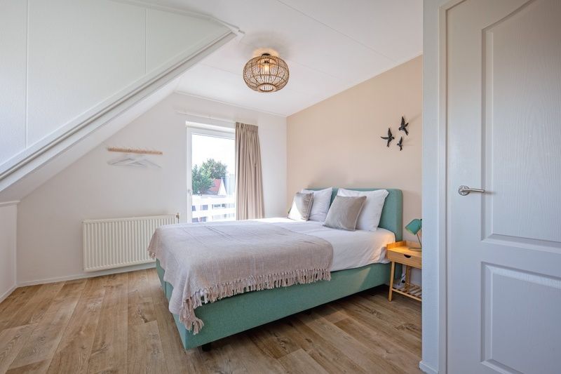 Lichte slaapkamer in Vogelweelde vakantiehuis, De Koog, Texel, met uitzicht op de omgeving.