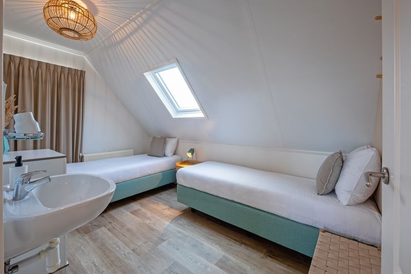 Tweepersoons slaapkamer in Vogelweelde, De Koog, Texel met moderne inrichting en dakraam.