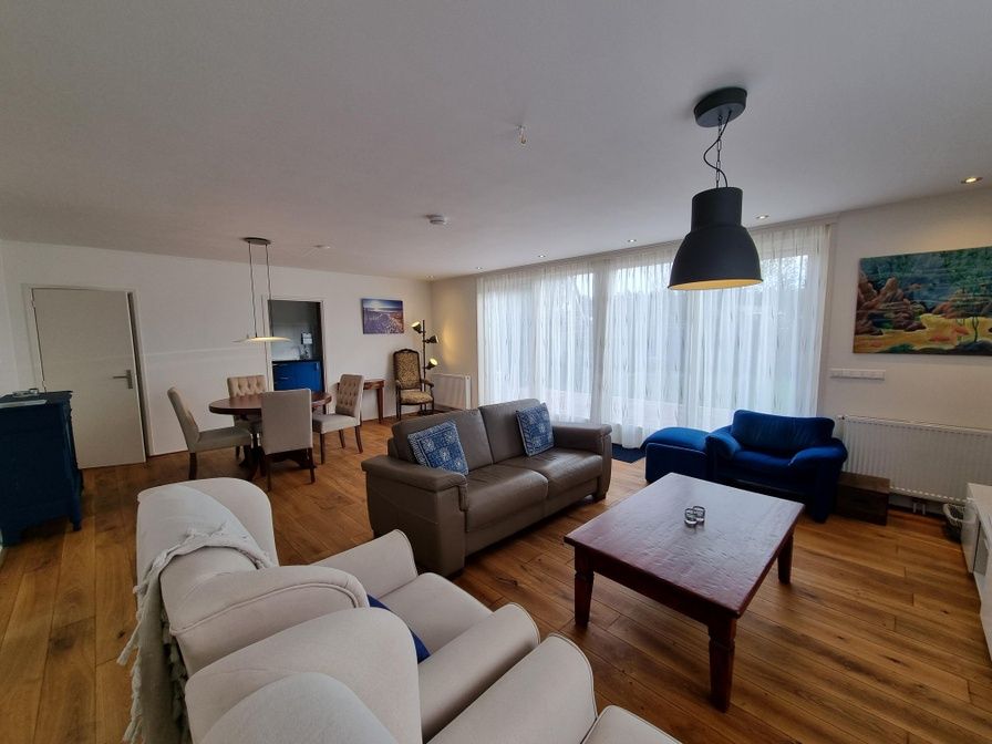 Gemuetliches Wohnzimmer im Bungalow Epelaan 13, De Koog, Texel. Geraeumiges Ferienhaus mit bequemen Sitzgelegenheiten und viel natuerlichem Licht.