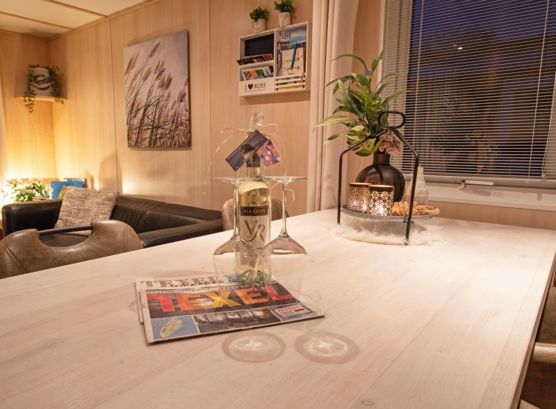 Details van het interieur in Chalet Bregkoog 27, De Koog Texel, met wijnglazen en lokale tijdschriften.