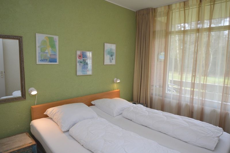 Geraeumiges Schlafzimmer im Appartement Kerckeland 68, De Koog, Texel mit bequemem Bett und natuerlichem Licht.