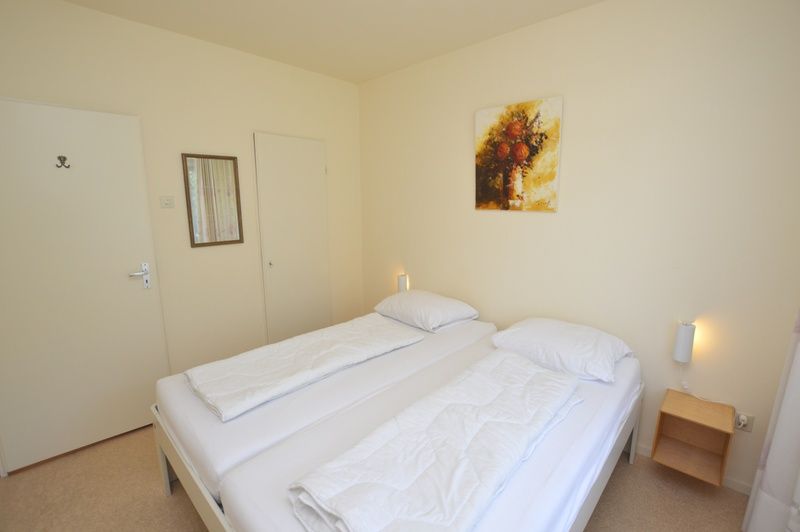 Slaapkamer in Appartement Kerckeland 64, De Koog, Texel met rustige sfeer en grote ramen.