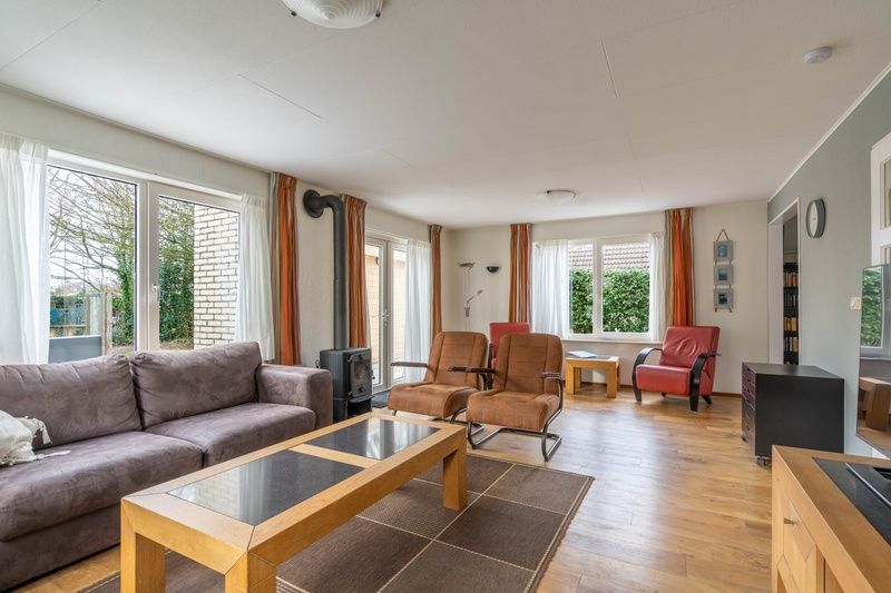 Gezellige zithoek in Vakantiehuis Kamperfoelie 43 met sauna in De Koog, Texel, met comfortabele stoelen en houtkachel.