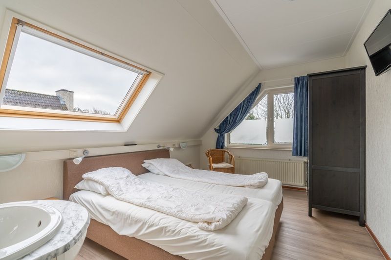 Sfeervolle slaapkamer in Vakantiehuis Kamperfoelie 43 met sauna, De Koog, Texel, met dakraam en comfortabele bedden.