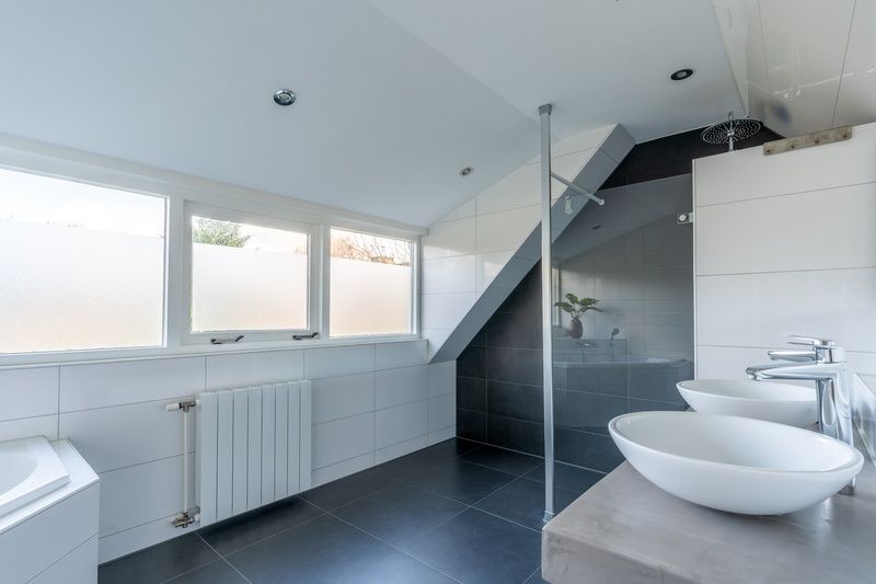 Luxe badkamer van Vakantiehuis Kamperfoelie 43 met sauna, De Koog, Texel, met ruime douche en dubbele wastafel.