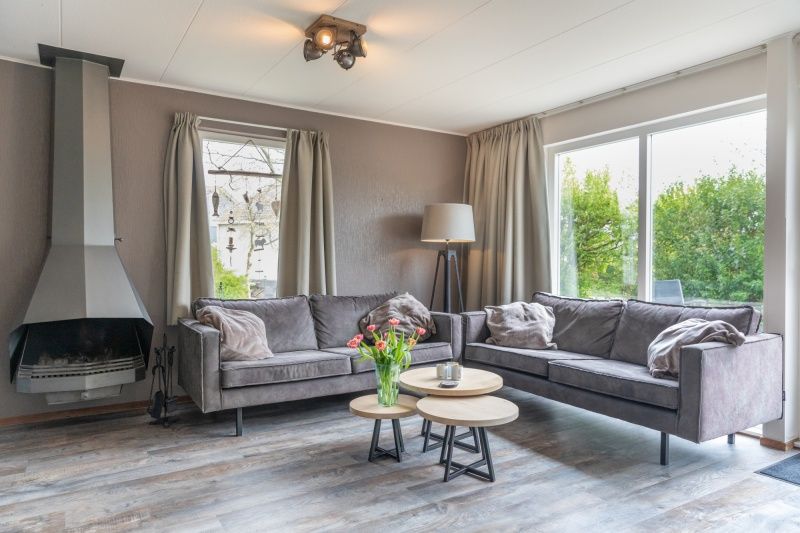 Gezellige woonkamer in Stappeland - De Groene Boei, vakantiehuis op Texel, met comfortabele banken en open haard.