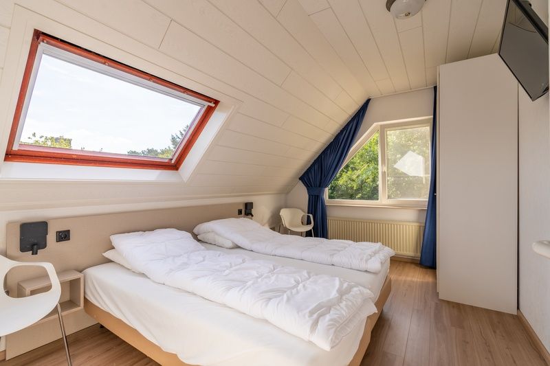 Slaapkamer in Vakantiehuis Kamperfoelie 89 De Koog Texel met twee bedden en veel natuurlijk licht voor een goede nachtrust.