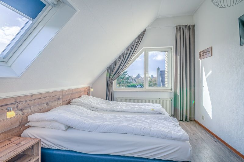 Komfortables Schlafzimmer im Ferienhaus Kamperfoelie 87, De Koog, Texel mit grossem Fenster und viel Tageslicht.