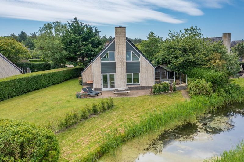 Uitzicht op Vakantiehuis Kamperfoelie 71 in De Koog, Texel, met groene omgeving.