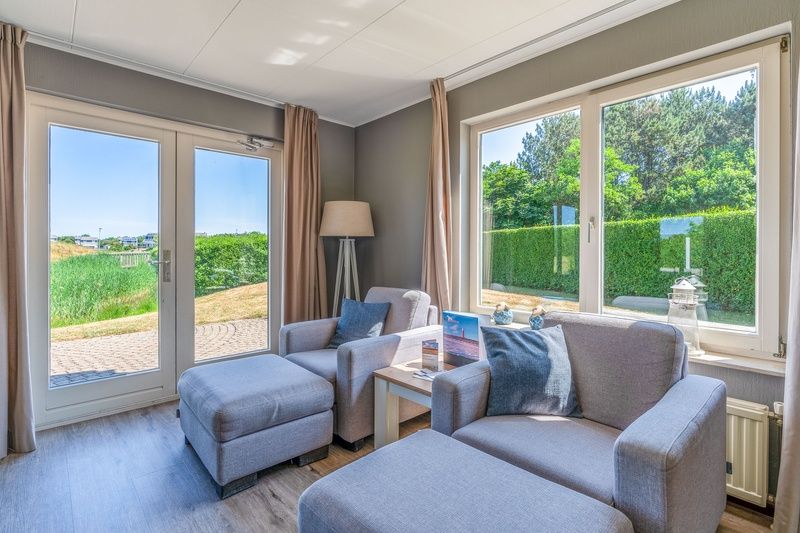 Zonnige leeshoek in Vakantiehuis Kamperfoelie 71, De Koog, Texel, met uitzicht op de tuin.