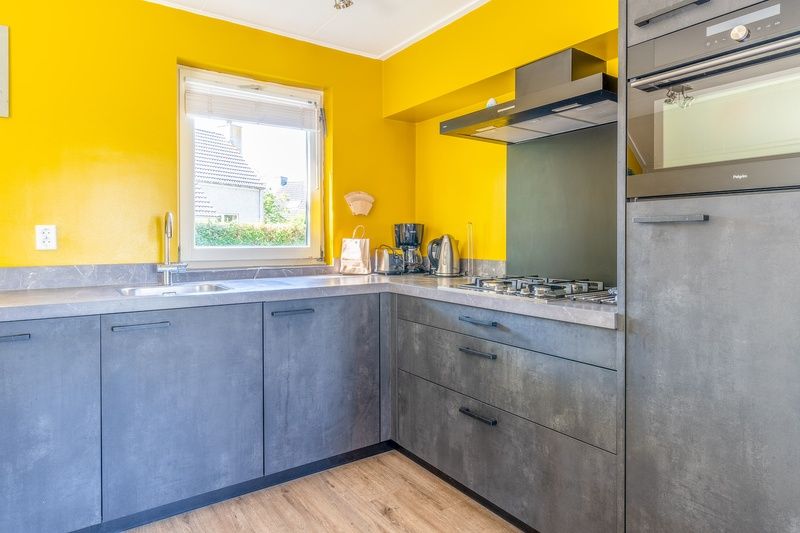 Moderne keuken in Vakantiehuis Kamperfoelie 71, Texel, met felgele accenten en alle voorzieningen.