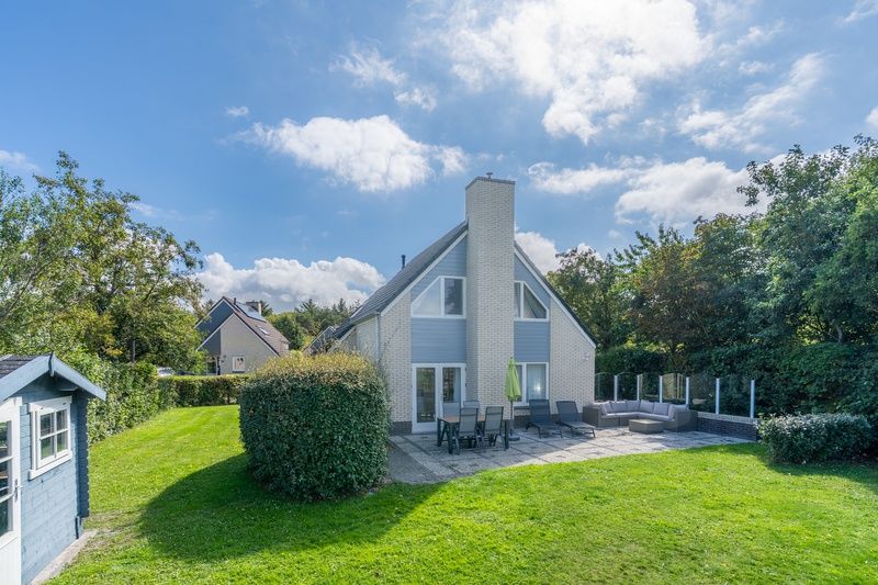 Sonnige Terrasse am Ferienhaus Honeysuckle 59 in De Koog, Texel mit bequemen Sitzgelegenheiten im Freien.