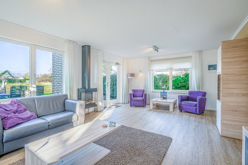 Helles Wohnzimmer des Ferienhauses Kamperfoelie 59 in De Koog, Texel mit Balkontueren zur Terrasse.