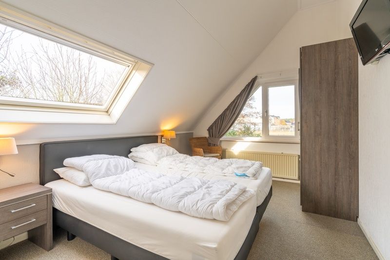 Komfortables Schlafzimmer im Ferienhaus Kamperfoelie 59, De Koog, Texel mit Doppelbett und Dachfenster.