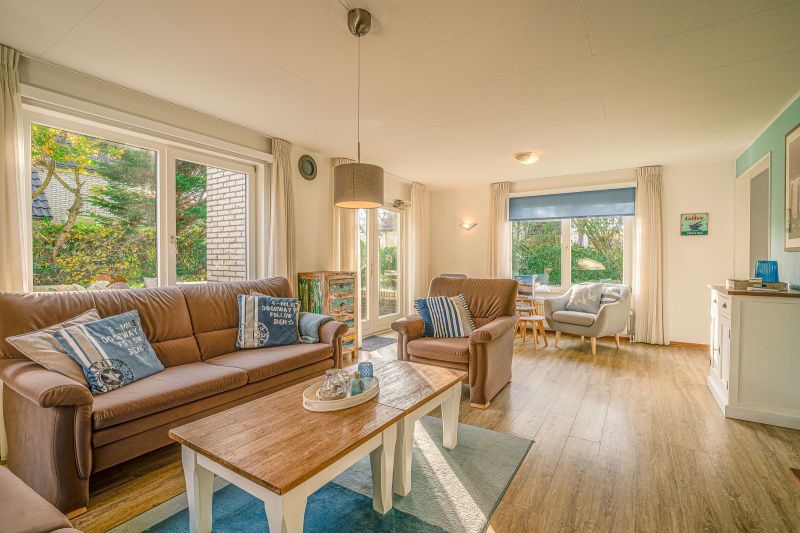 Lichte woonkamer van Vakantiehuis Kamperfoelie 65 in De Koog, Texel met uitzicht op tuin.