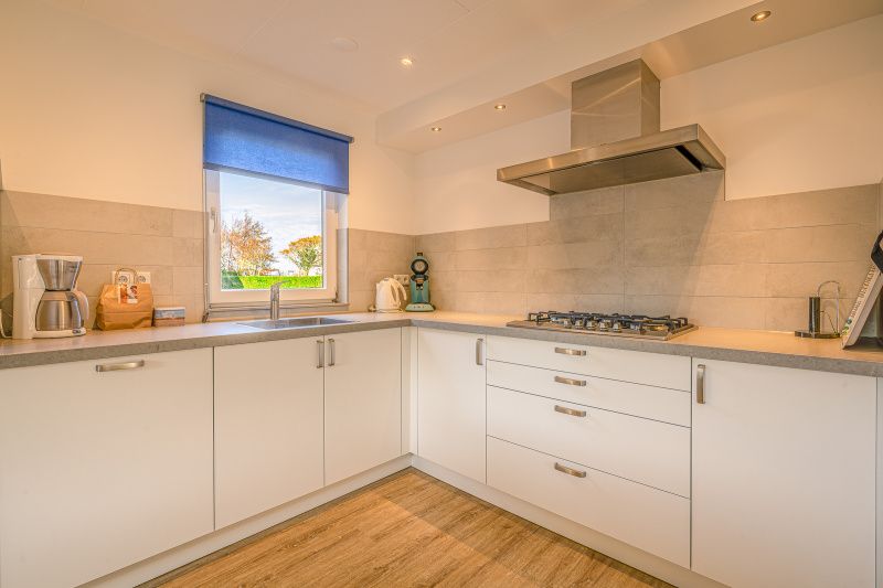 Moderne keuken van Vakantiehuis Kamperfoelie 65, De Koog, Texel met strakke afwerking en apparatuur.