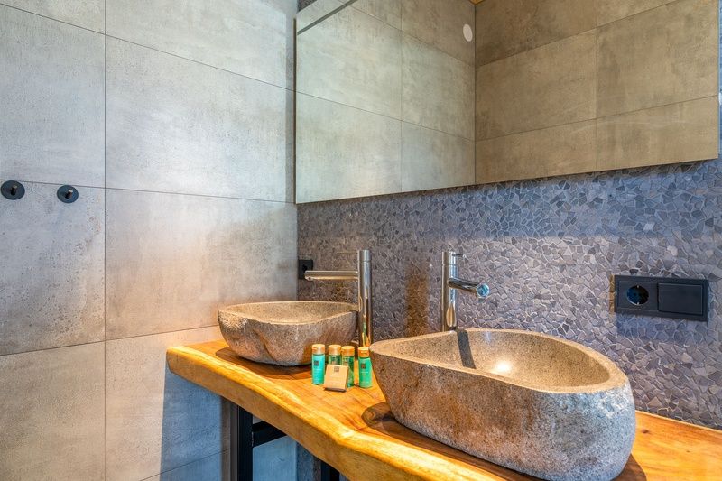 Stilvolles Badezimmer in der Villa 183 mit Whirlpool in De Koog Texel, mit Natursteinwaschbecken und luxurioeser Verarbeitung.