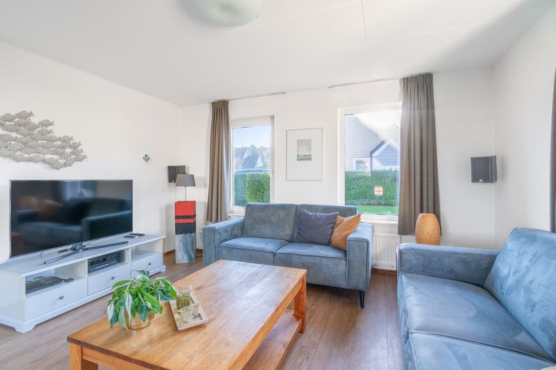 Moderne Sitzecke im Ferienhaus Honeysuckle 75, Texel mit Blick auf den Garten.