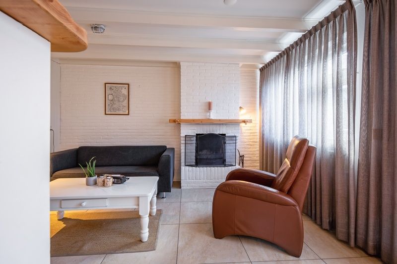 Sfeervolle open haard in 32b Pollux, vakantiehuis in De Koog, Texel, perfect voor ontspanning na een dag op de Waddeneilanden.