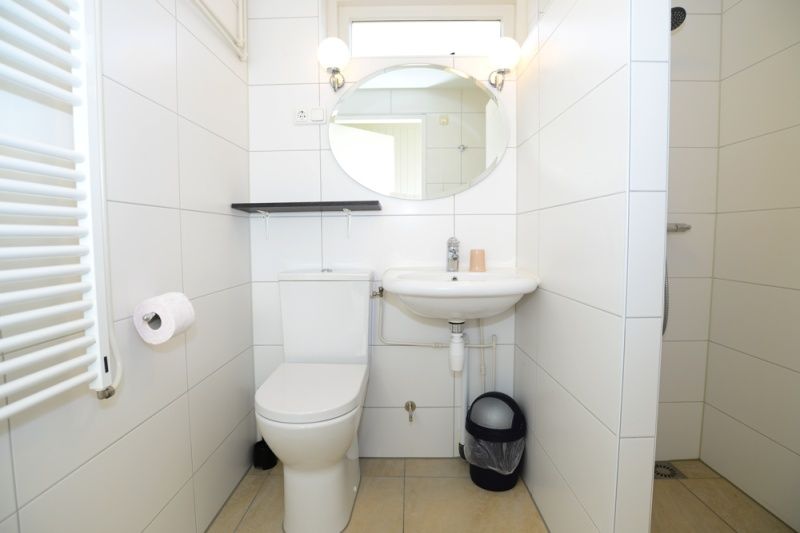 Frisse badkamer in vakantiehuis 32b Pollux, De Koog, Texel met toilet en wastafel, ideaal voor comfort op de Waddeneilanden.
