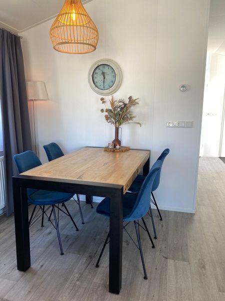 Gemuetliches Wohnzimmer im Chalet Bregkoog 94, De Koog, Texel. Bequemes Sofa und stilvolle Einrichtung fuer einen entspannten Aufenthalt.