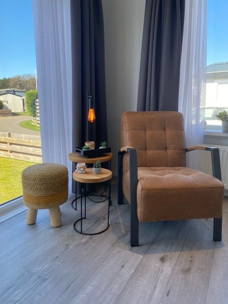 Chalet Bregkoog 94, Texel. Gemuetliche Leseecke mit Sessel und Beistelltisch im sonnigen Wohnzimmer des Ferienhauses.
