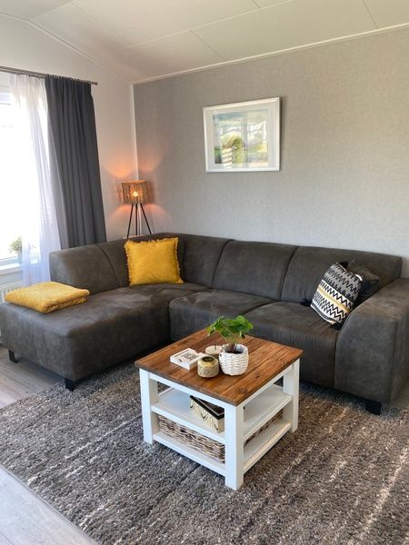 Essecke im Chalet Bregkoog 94, De Koog. Moderner Holztisch mit blauen Stuehlen, ideal fuer gemuetliche Mahlzeiten auf Texel.