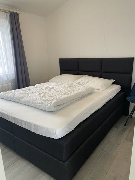 Chalet Bregkoog 94, Texel. Moderne TV-Ecke mit grossem Bildschirm und stilvollem Schrank im Wohnzimmer des Ferienhauses.