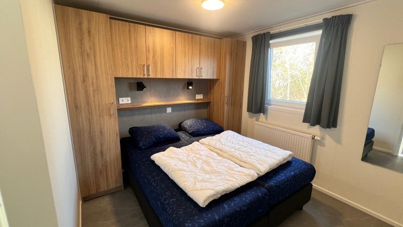 Slaapkamer met tweepersoonsbed in Chalet Type 1, De Koog, Texel voor een comfortabele nachtrust op de Waddeneilanden.