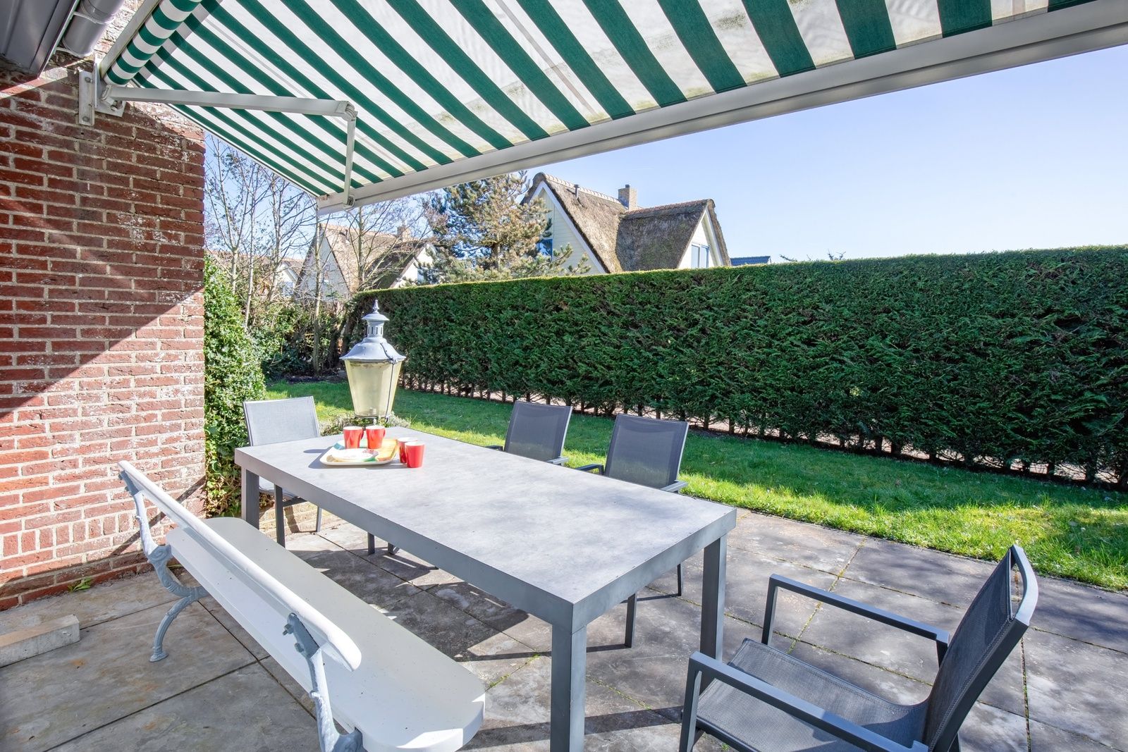 Gezellig terras met schaduw bij De Schutstal vakantiehuis in De Koog, Texel