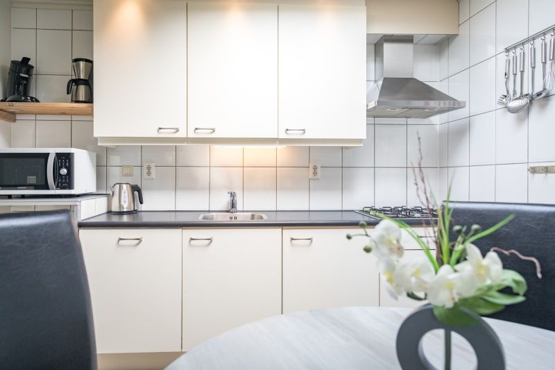 Stijlvolle keuken in vakantiehuis Zeelucht in De Koog, Texel met eethoek en apparatuur.