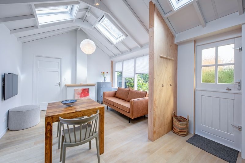 Stijlvolle binnenruimte van vakantiehuis Pippa, Texel met houten accenten en grote ramen.