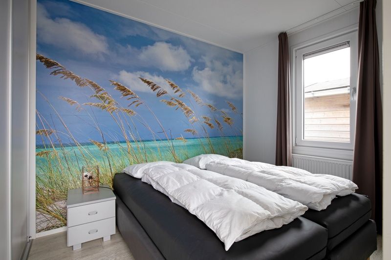 Slaapkamer in Chalet Bregkoog 261, Chaletpark Bregkoog, De Koog, Texel, met een rustgevend strandthema en comfortabel bed.