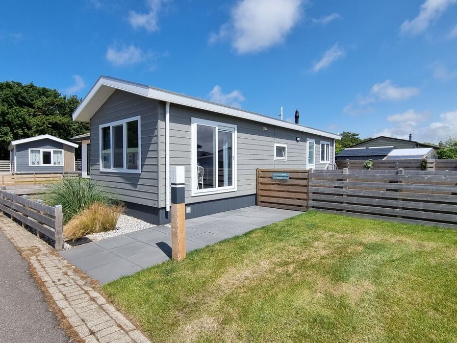 Chaletpark Bregkoog 82 in De Koog, Texel biedt een modern vakantiehuis met ruime veranda en groene omgeving.