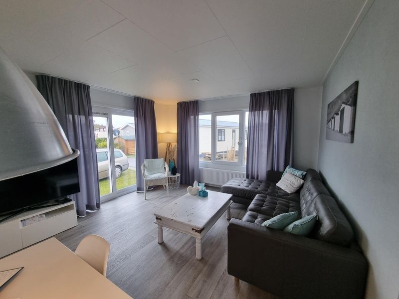 Woonkamer van Chalet Bregkoog 82, De Koog, Texel met comfortabele zithoek en grote ramen.