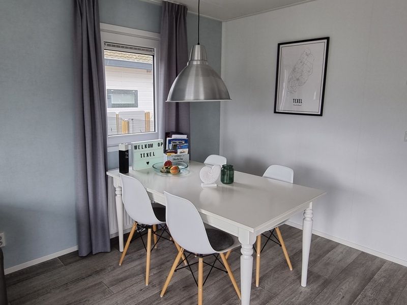 Eethoek in Chalet Bregkoog 82, De Koog, Texel met moderne tafel en stoelen, ideaal voor familie.