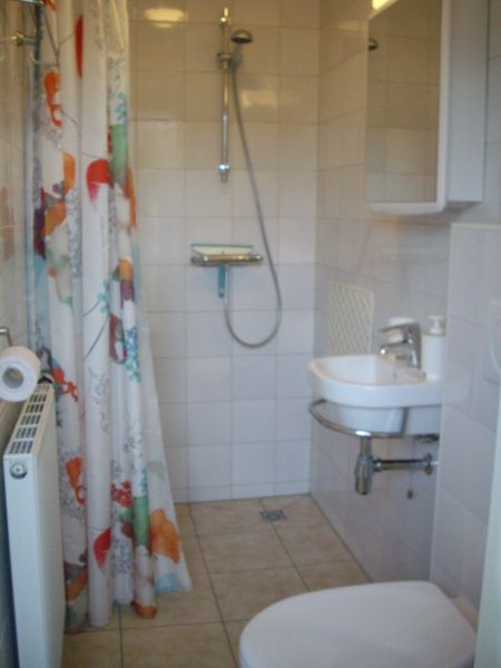 Moderne badkamer in vakantiehuis Plevierstraat 21, De Koog, Texel, met douche en wastafel op de Waddeneilanden.