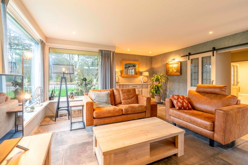 Lichte woonkamer in Huis ter Duin, vakantiehuis in De Koog, Texel met grote ramen.