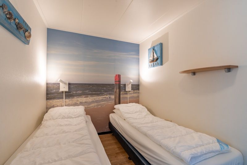 Sfeervolle slaapkamer met strandthema in Appartement Anna 218, De Koog, Texel, voor een goede nachtrust.