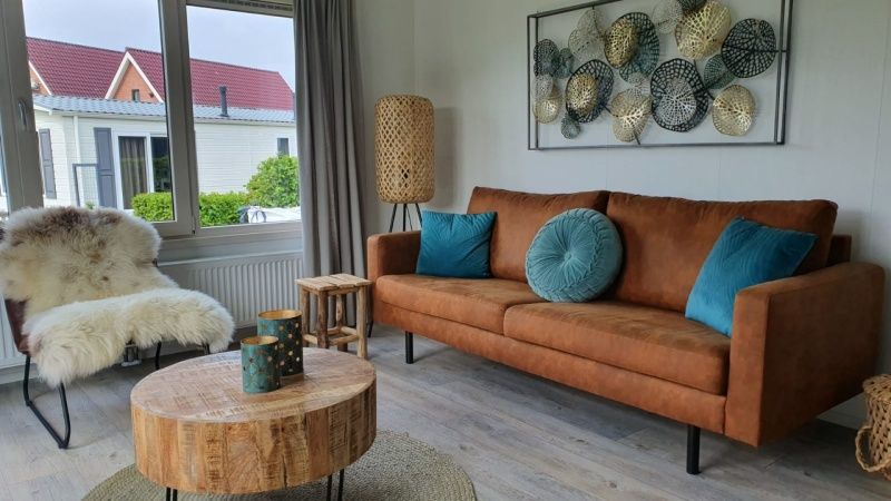 Gezellige woonkamer van Chalet Bregkoog 154 in De Koog, Texel met comfortabele bank.