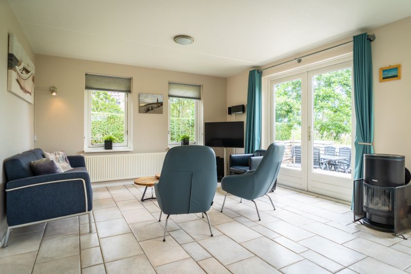 Gezellige zithoek in Villa 6 personen, De Koog Texel, met lichtinval en toegang tot het terras.